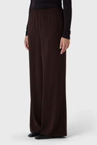Brown wide-leg pants worn by a person on a white background